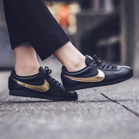 black nikes with gold swoosh.